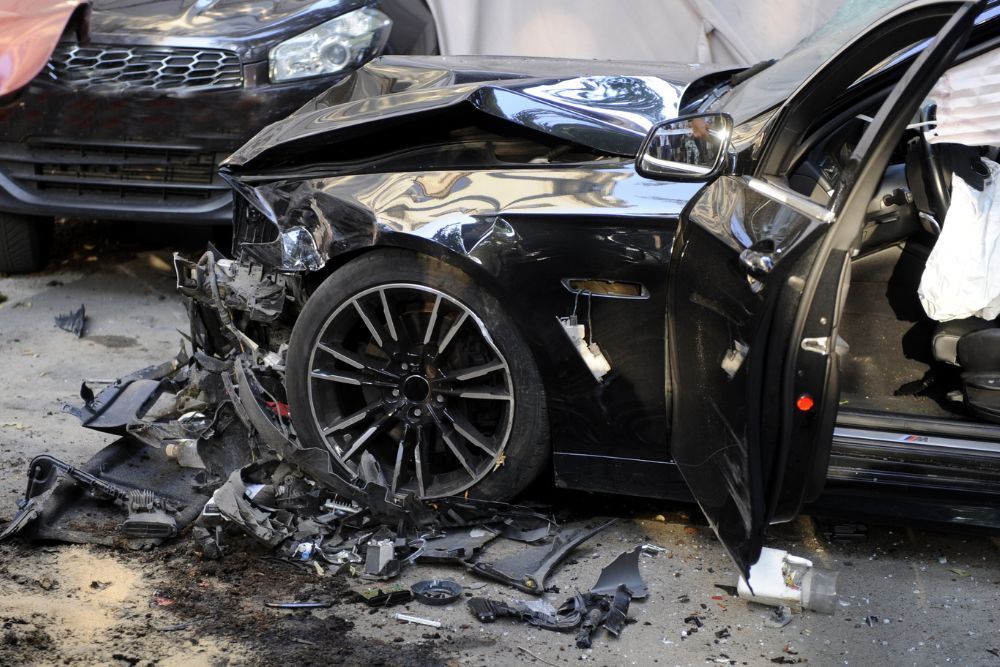Black mustang with front end damage from a car accident