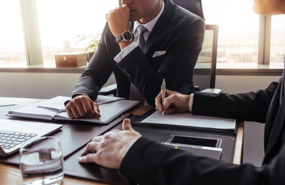 Business professionals meeting, discussing documents in a modern office setting.