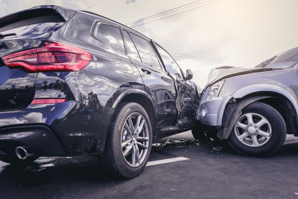 Car accident with significant damage to two vehicles on a street.