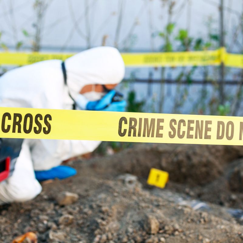 Wrongful death crime scene investigation. Forensic science specialist photographing human remains.