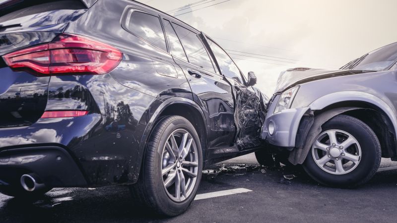 Car accident with significant damage to two vehicles on a street.