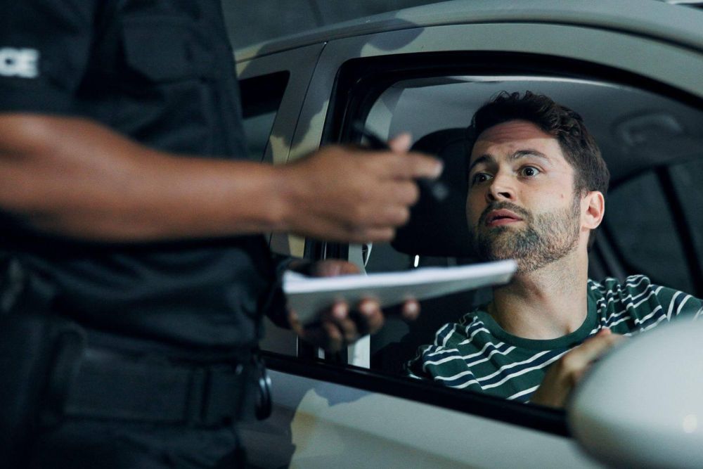 a man in a police uniform is talking to a man in a car