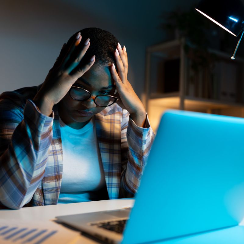 Mujer preocupada con una computadora portátil, simbolizando errores en las redes sociales que pueden afectar un caso en un asilo de ancianos.