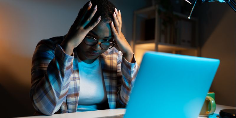 Worried woman at laptop, symbolizing social media mistakes that can impact a nursing home case