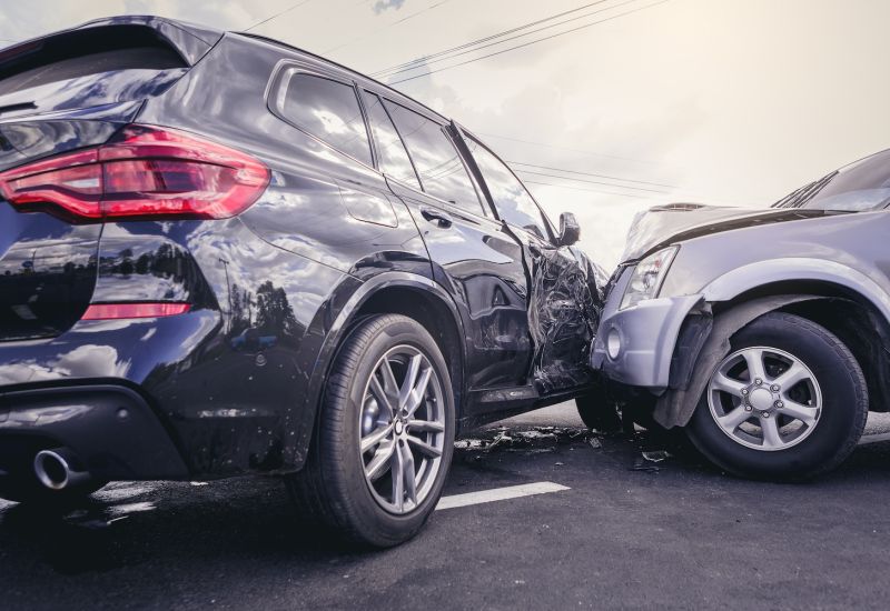 Car accident with significant damage to two vehicles on a street.