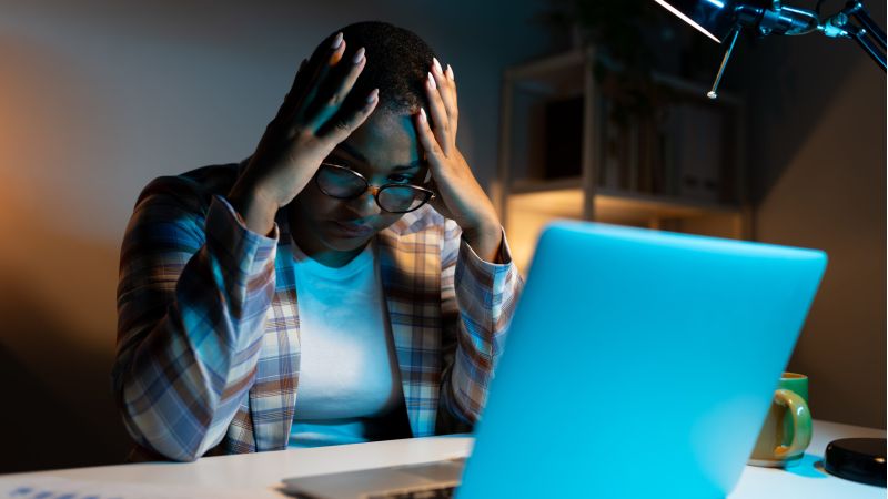 Worried woman at laptop, symbolizing social media mistakes that can impact a nursing home case