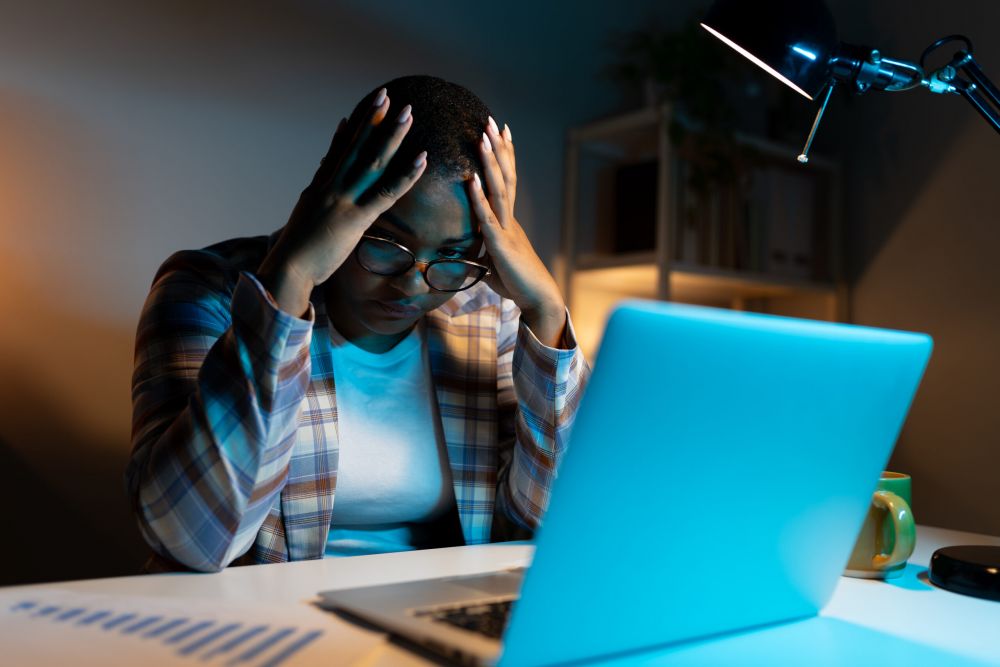 Worried woman at laptop, symbolizing social media mistakes that can impact a nursing home case