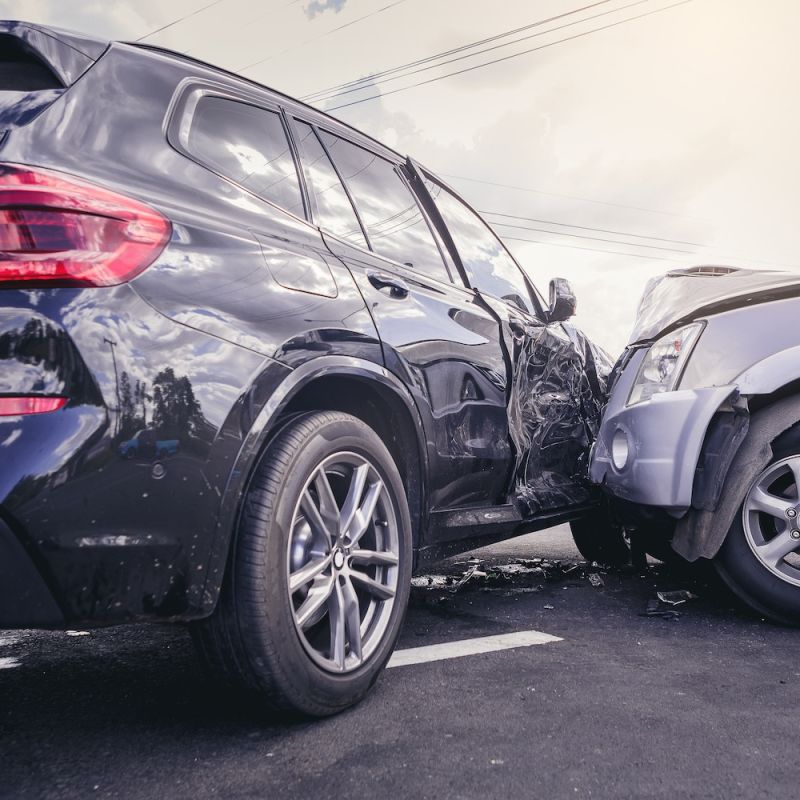 Car accident with significant damage to two vehicles on a street.