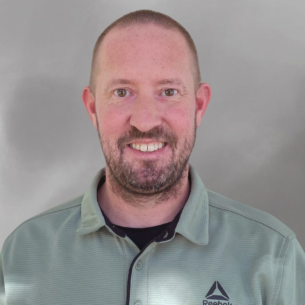 Matthew Spencer in green Reebok shirt against a plain background.