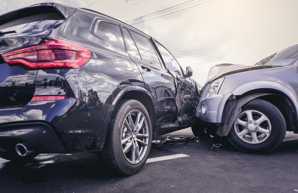 Car accident with significant damage to two vehicles on a street.