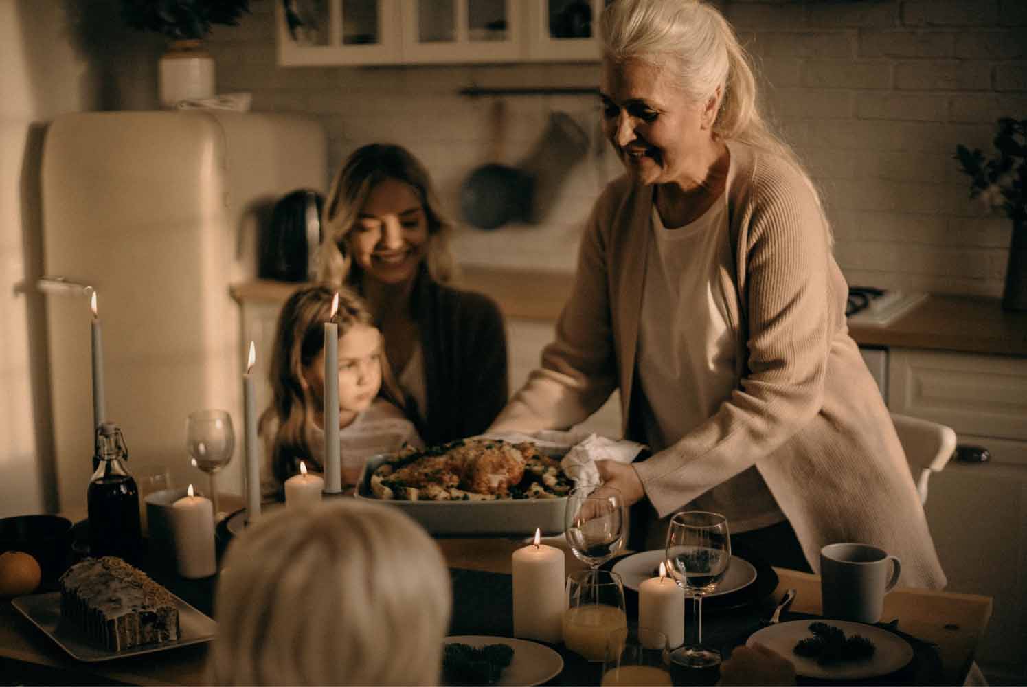 Grandma serving the Thanksgiving turkey while daughter and granddaughter look on