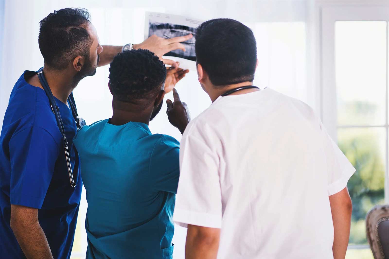 3 male staff members of a nursing home review an elderly patient’s chart