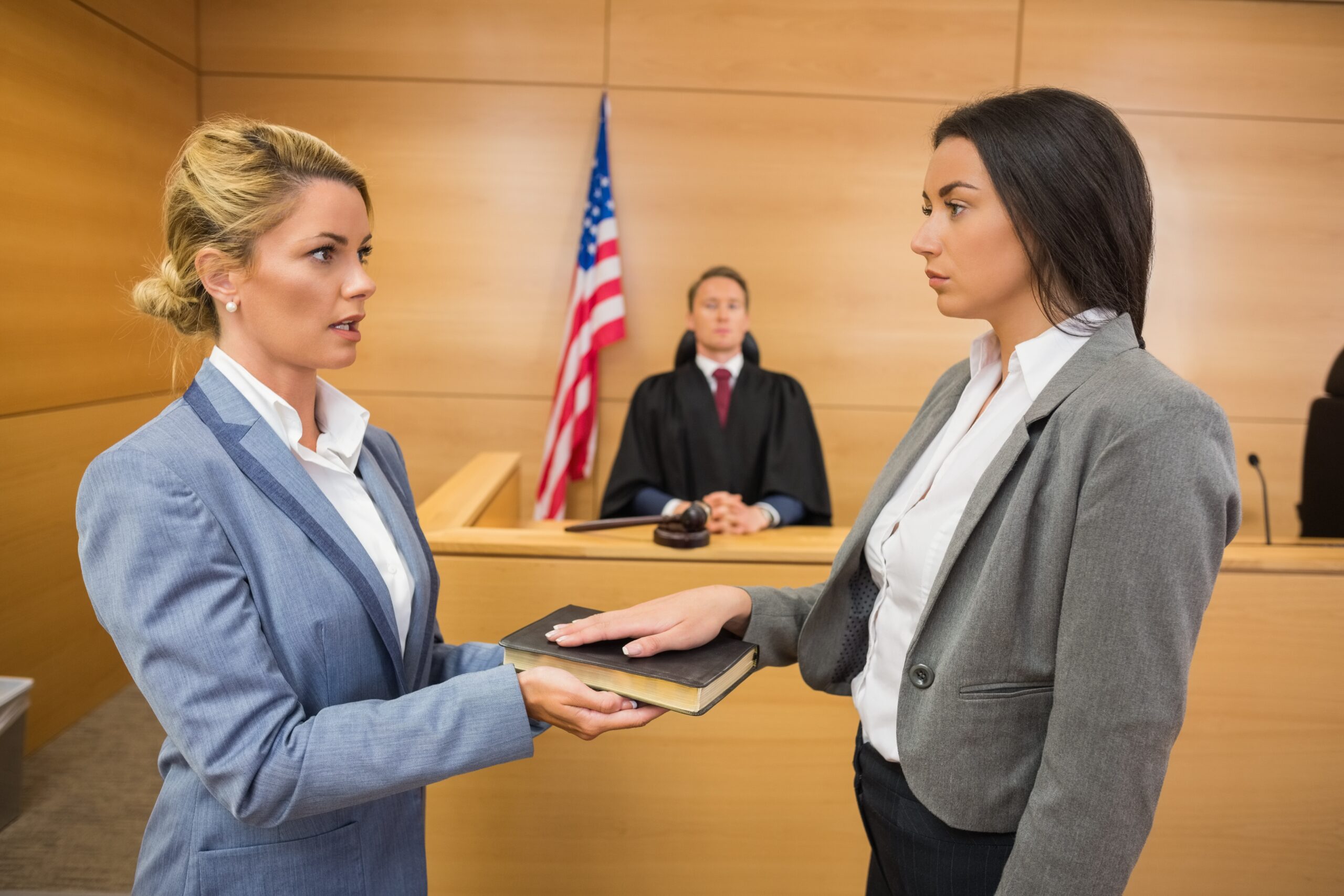 Female witness taking an oath before a male judge prior to testifying