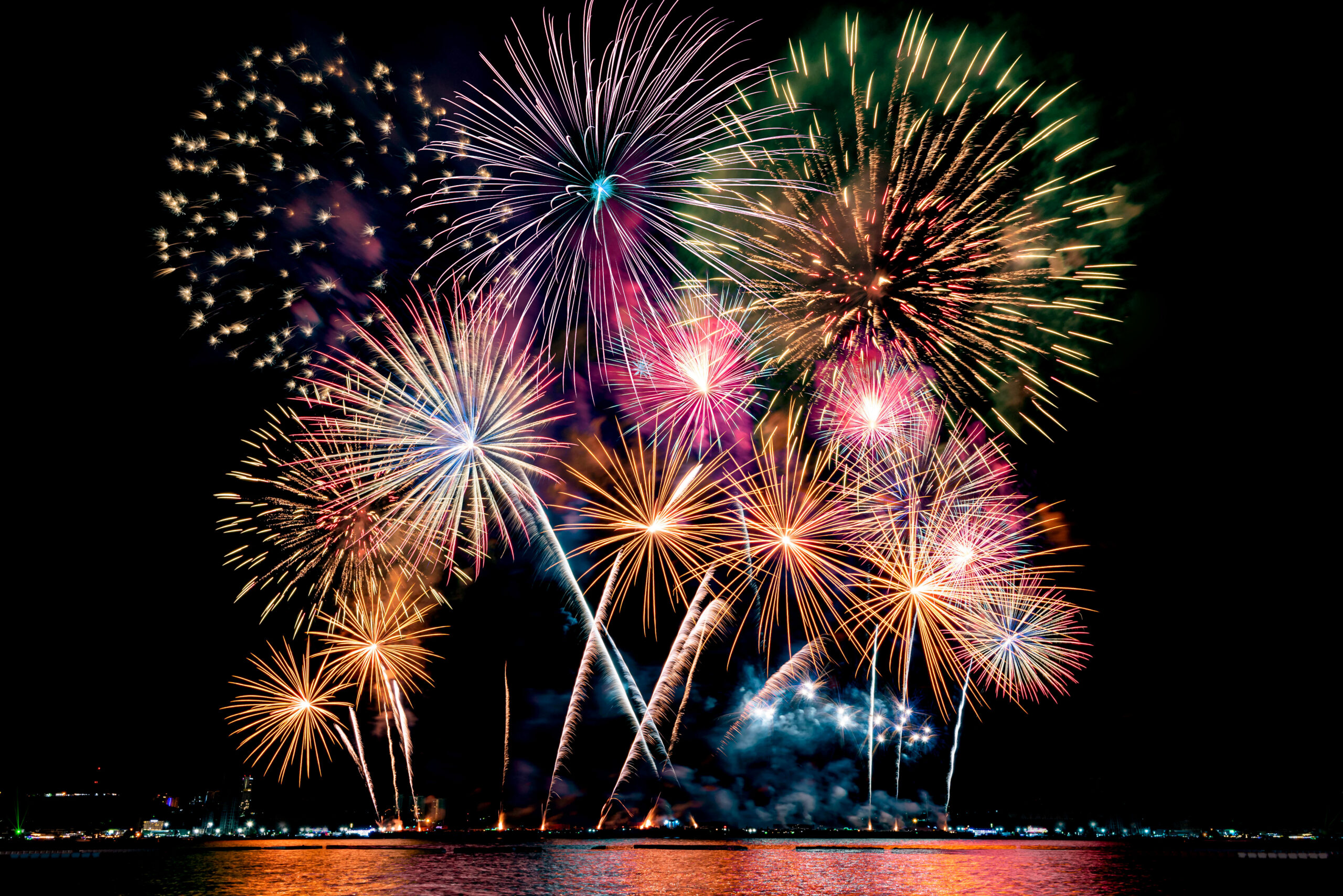 Beautiful colorful fireworks display on 4th of July, with multi color reflection on the water