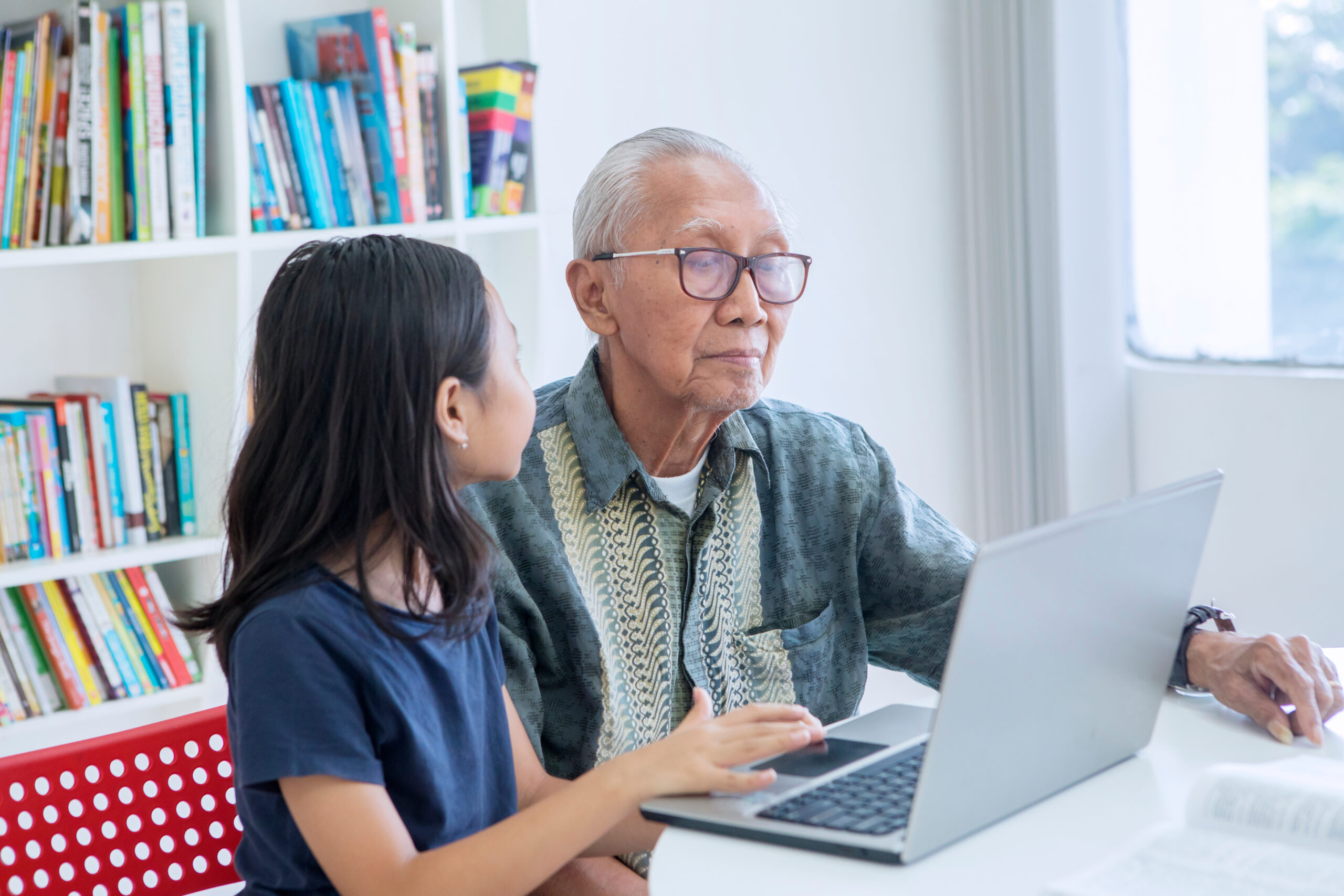 Granddaughter shows her Centenarian grandfather pictures on her laptop