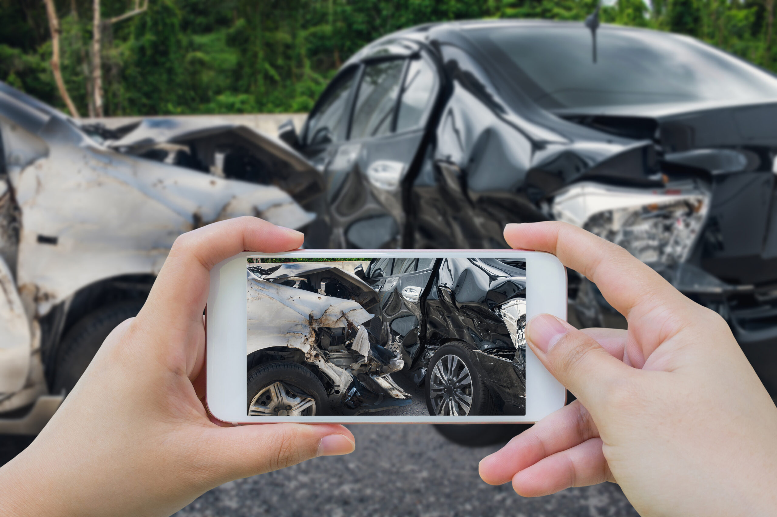 Woman using smartphone to take pictures of the auto accident scene caused by a drunk driver