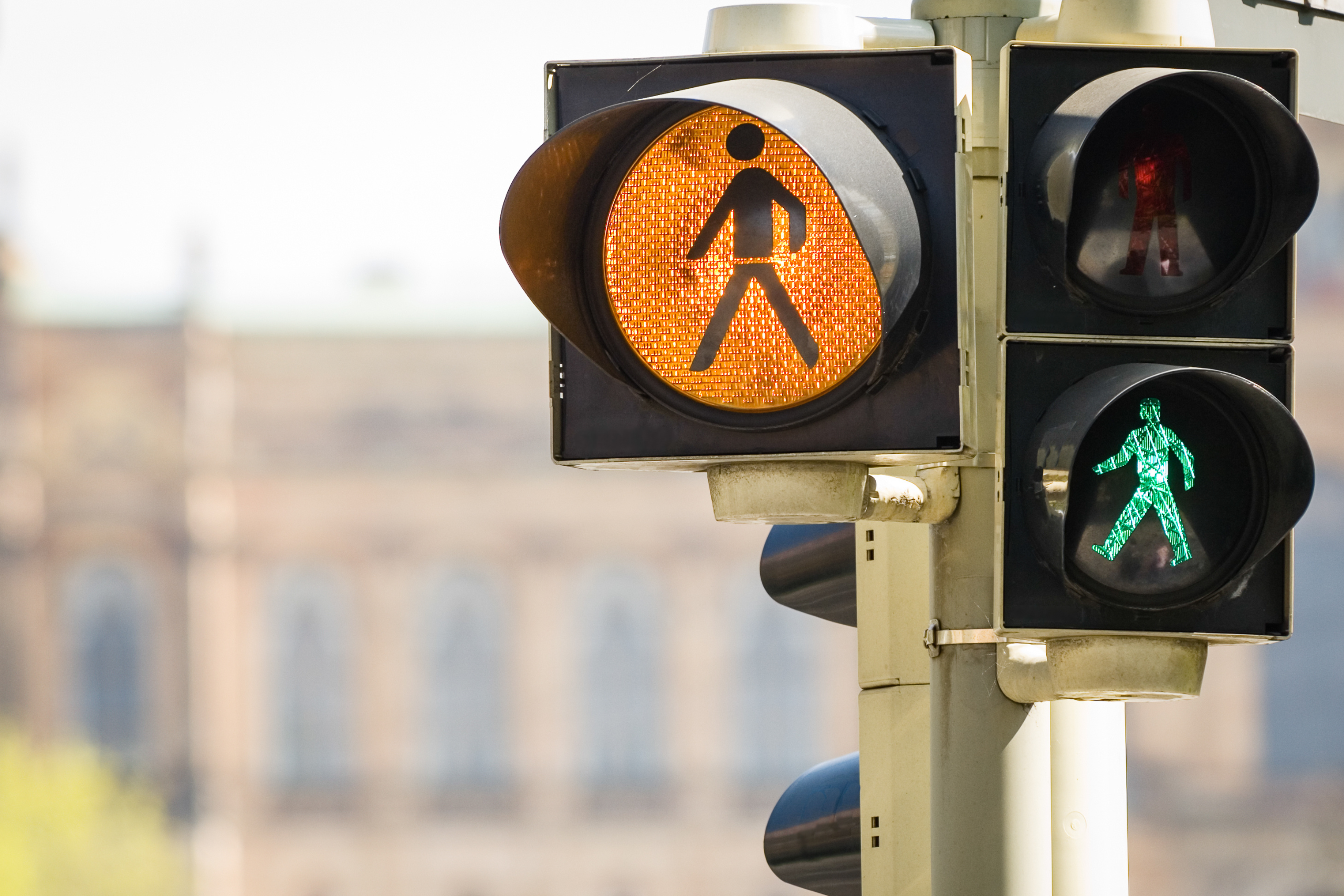 Close-up of a pedestrian traffic light showing both red and green signals, underscoring pedestrian safety during National Traffic Awareness Month.