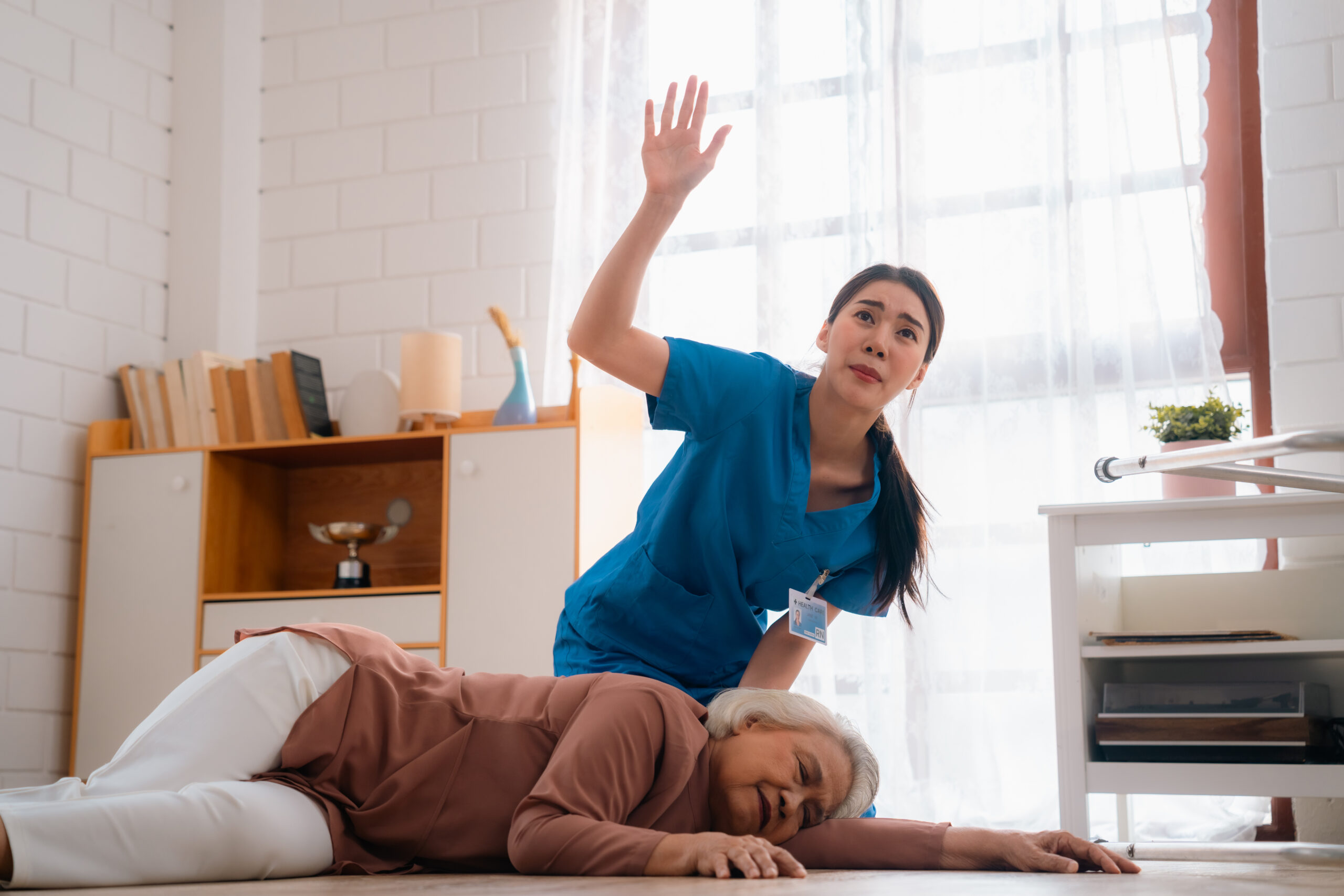 Nurse assisting an elderly woman who has fallen, emphasizing the importance of fall prevention and immediate care in nursing homes.