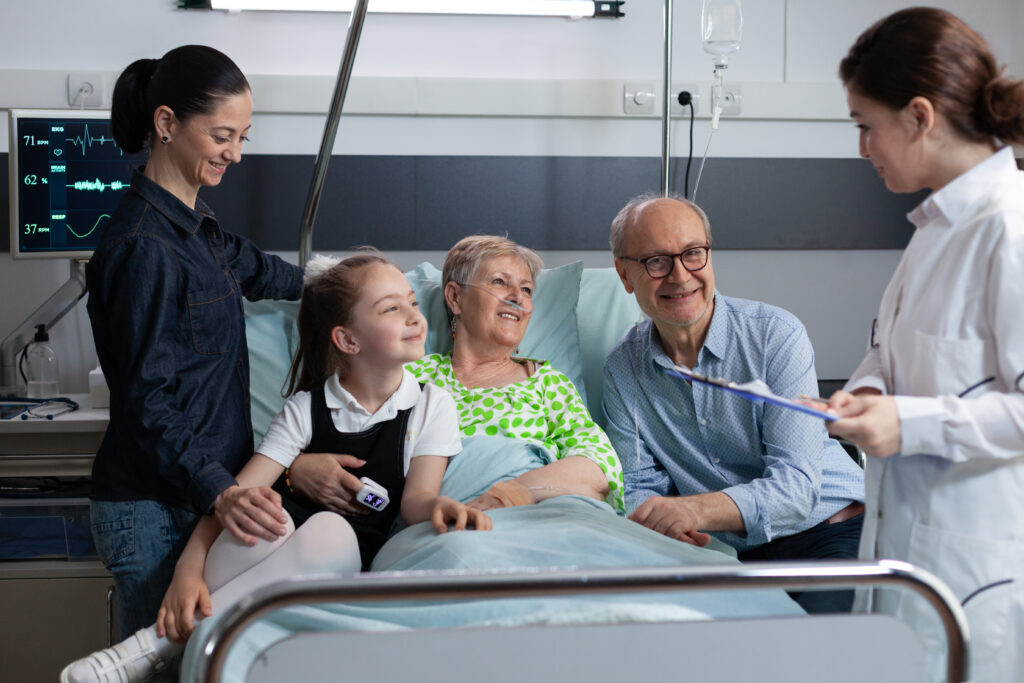 Elderly woman in hospital bed surrounded by smiling family and doctor, showing recovery and support in pressure ulcer care