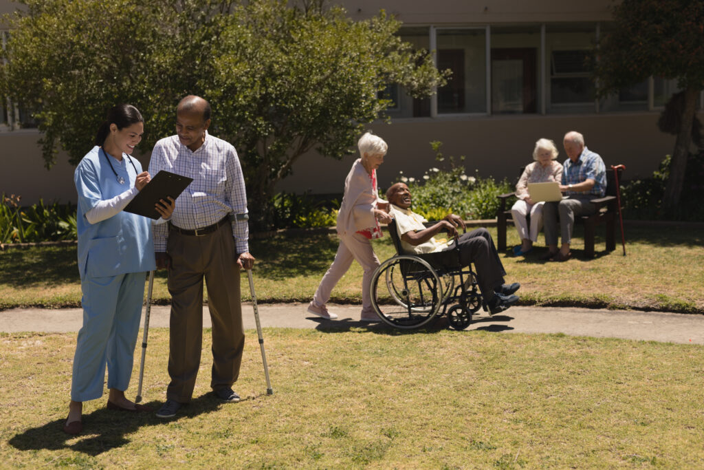 Elderly residents engaging with caregivers outdoors; Williams DeLoatche supports families in nursing home abuse cases.