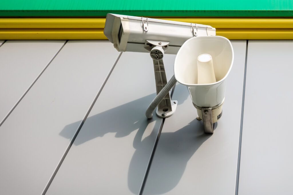 Surveillance camera and speaker mounted on building; Williams DeLoatche urges prompt video requests after premises injuries.
