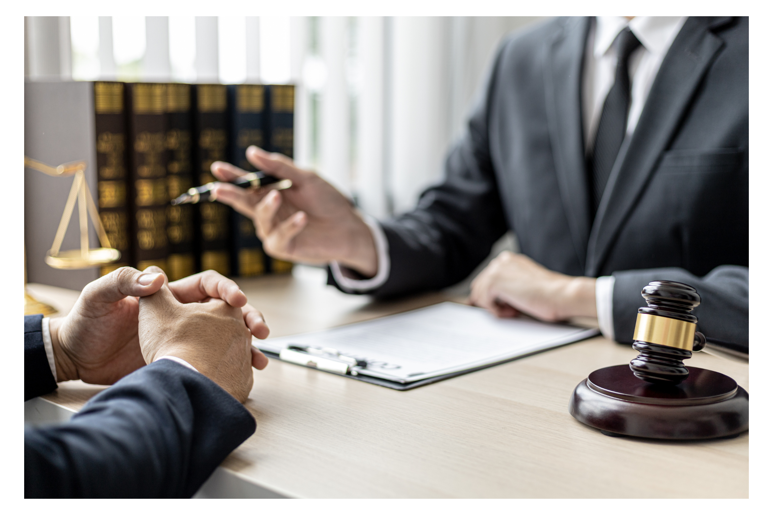 A professional consultation in progress with a lawyer in a suit explaining legal points to a client, with a focus on gavel and justice scales, emphasizing the legal aspects of nursing home advocacy and the importance of clear communication.