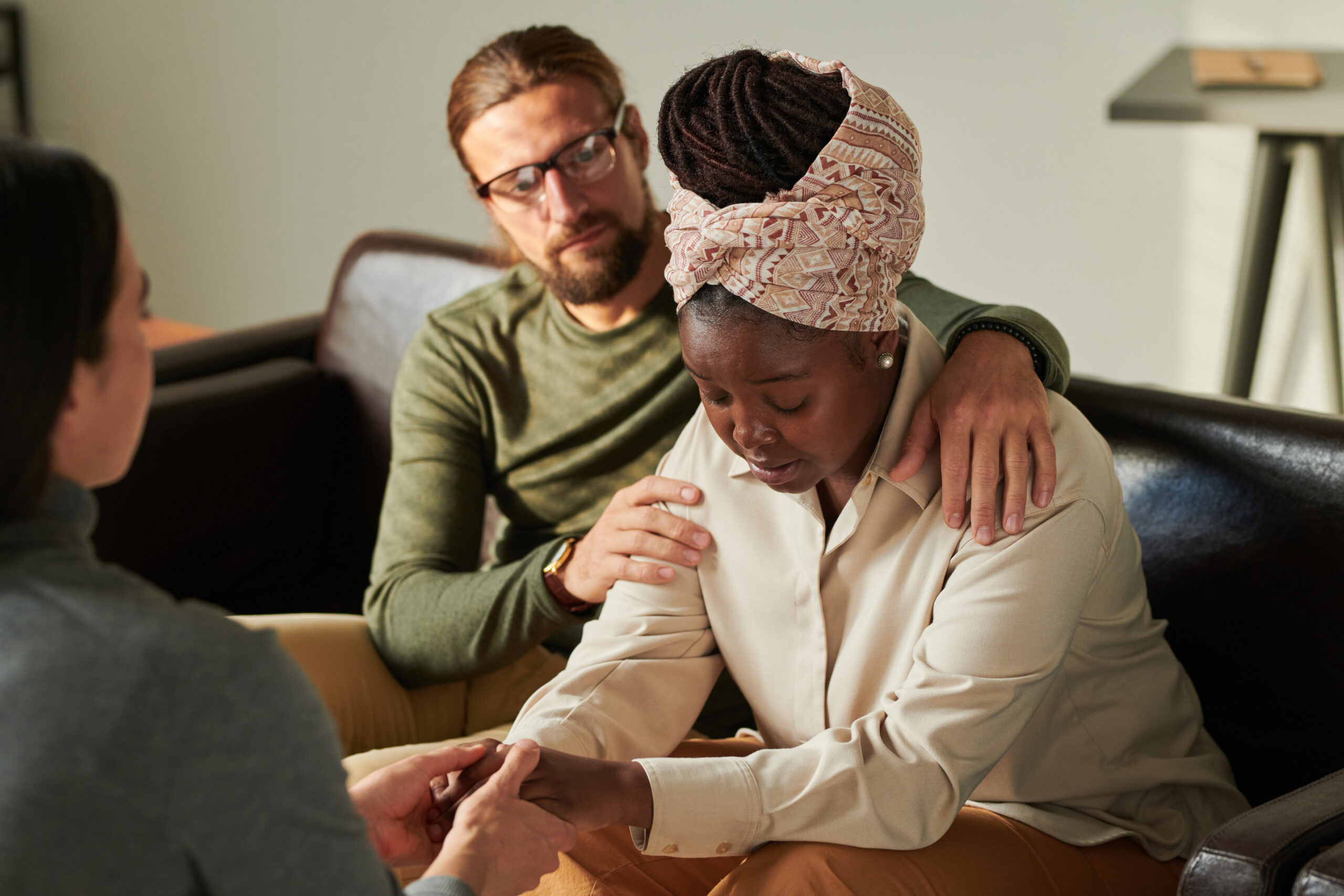 Woman receiving emotional support from loved ones during a difficult conversation, symbolizing the stress of personal injury claims.