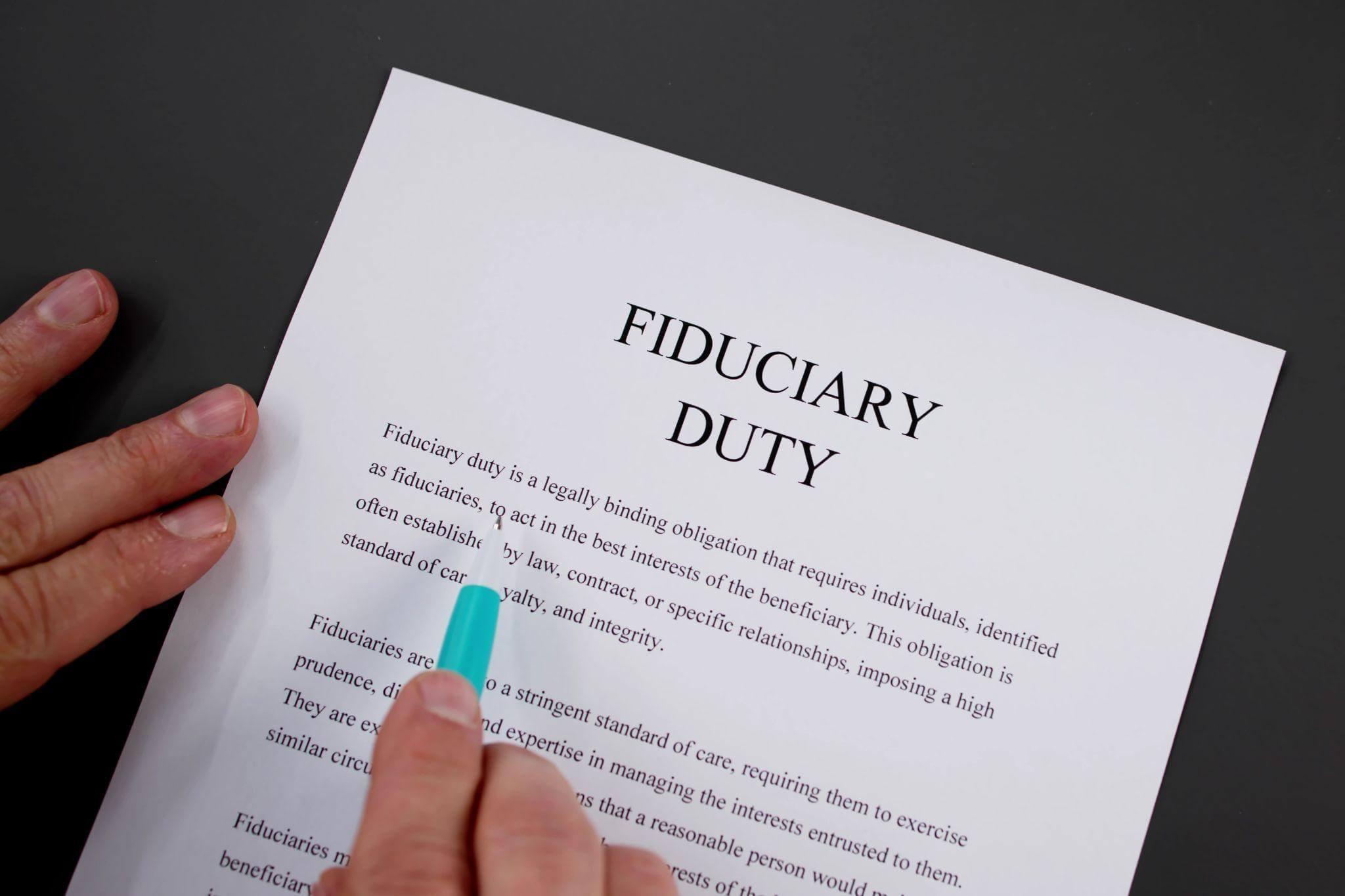 a person is writing on a piece of paper titled "Fiduciary Duty"