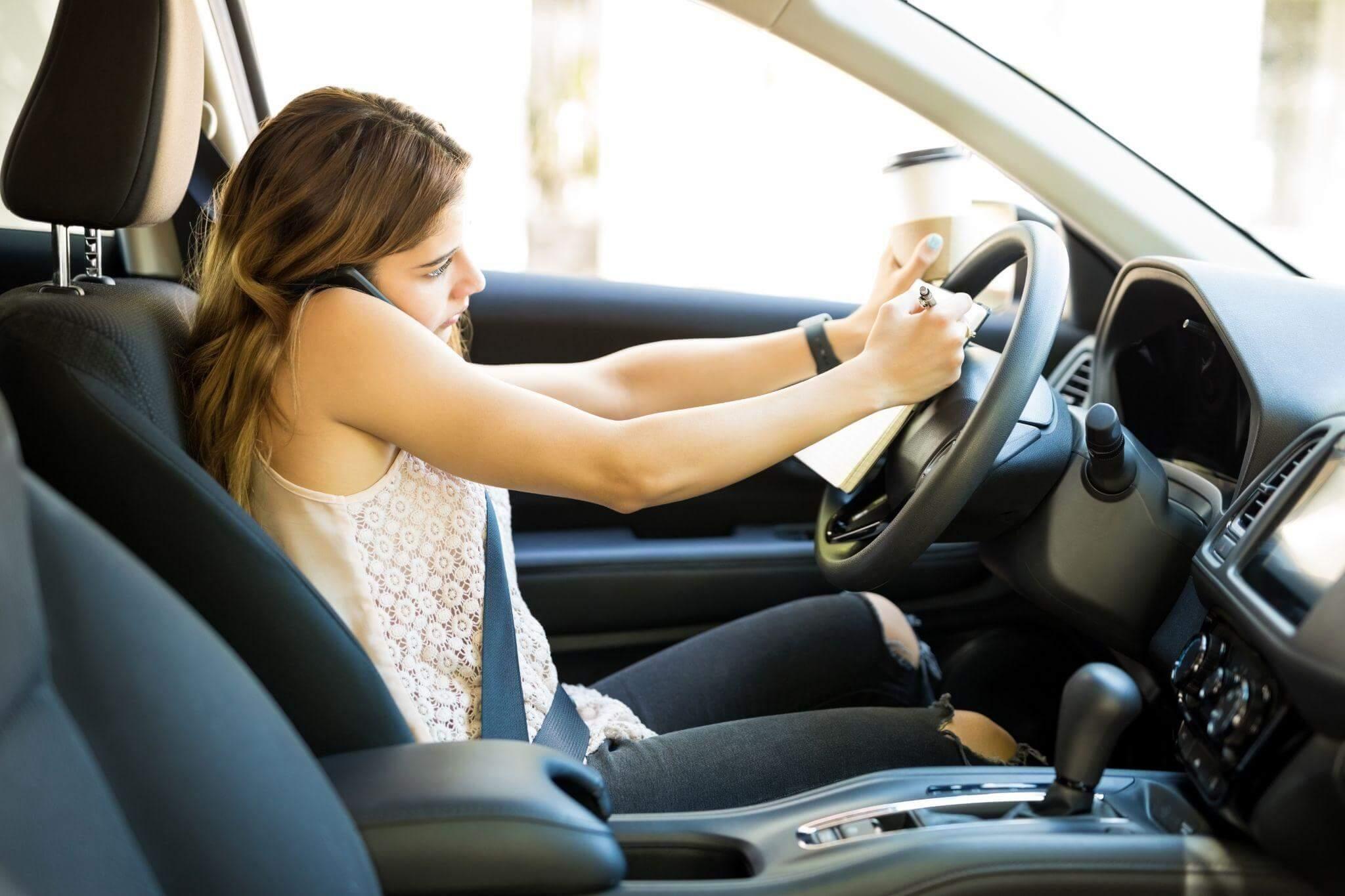 a woman sitting in a car holding a steering wheel