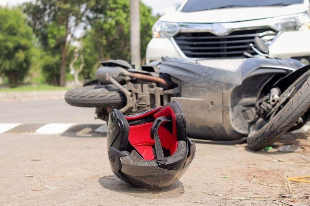 Motorcycle helmet resting by the road next to motorcycle accident. 