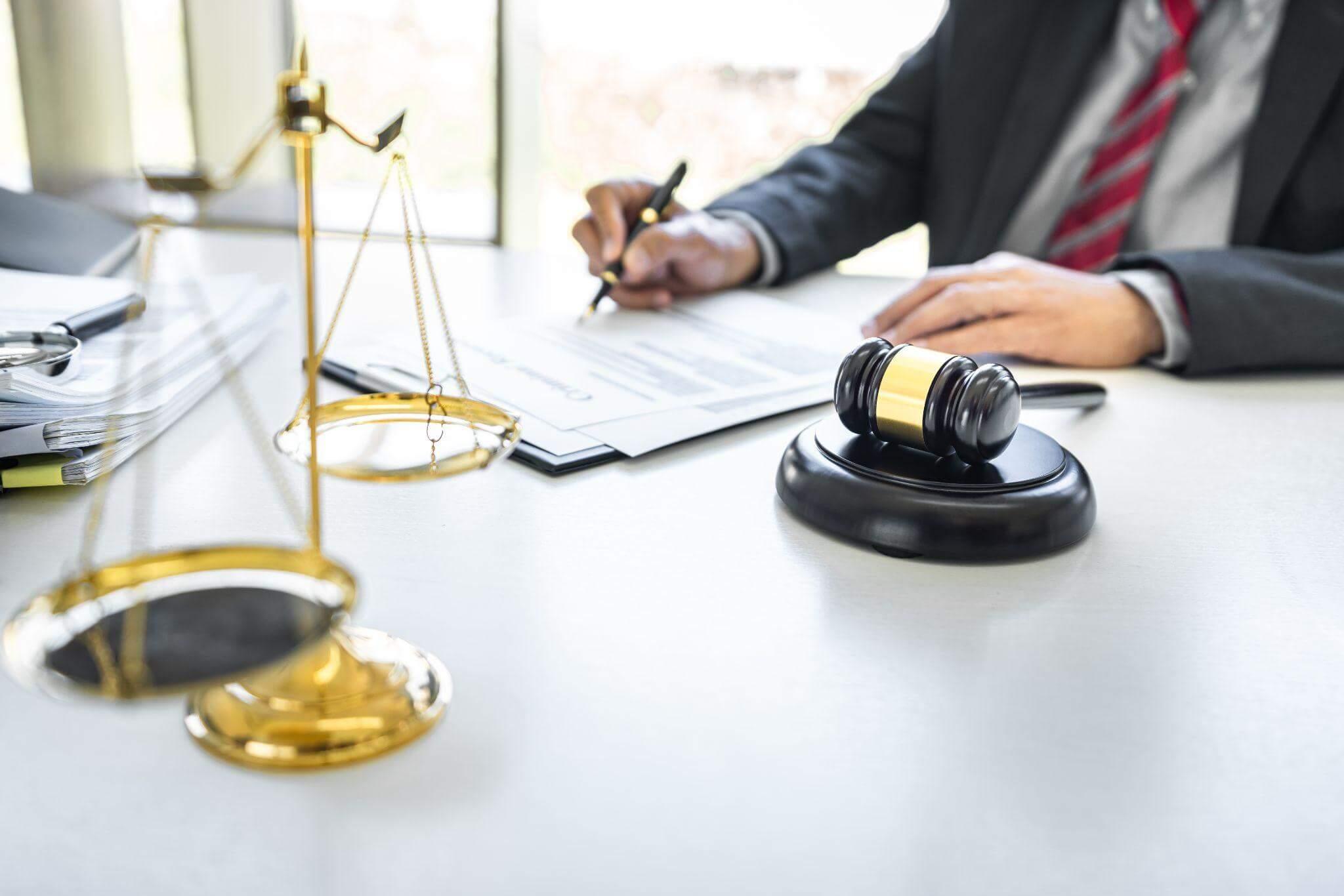 Man at desk with scale of justice
